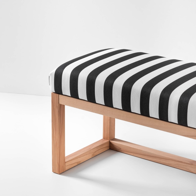 Stylowa ławka z tapicerką w paski i jasnym drewnem