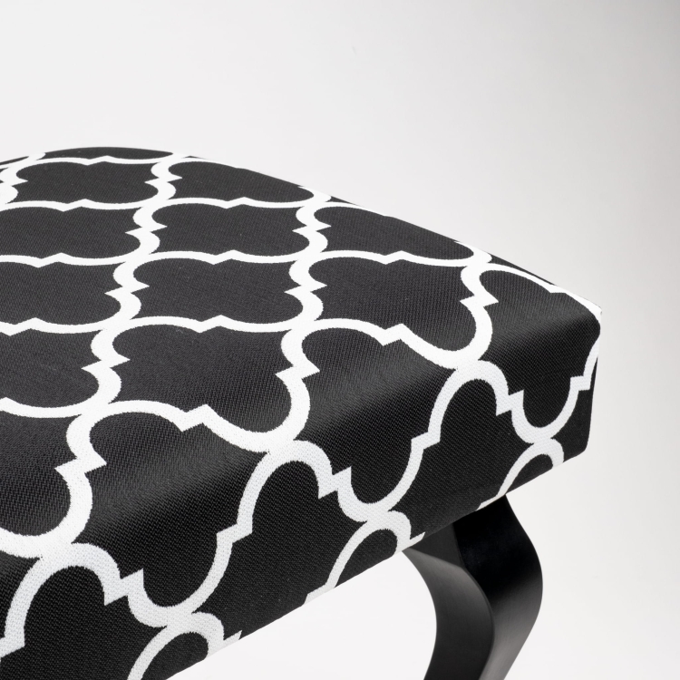 Dekoracyjna ławka z ozdobną tapicerką i czarnymi nogami