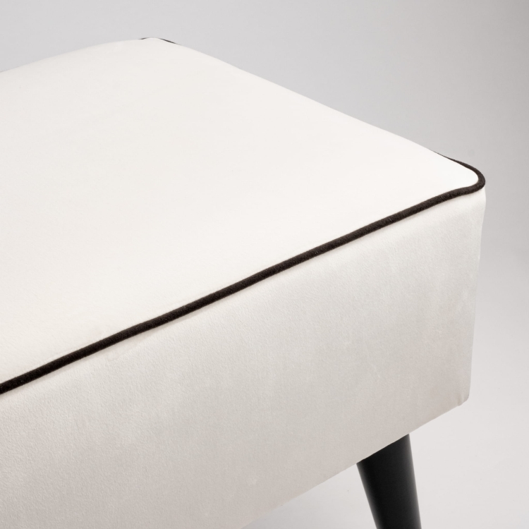 Tapicerowana ławka w kolorze kremowym z czarnymi nogami