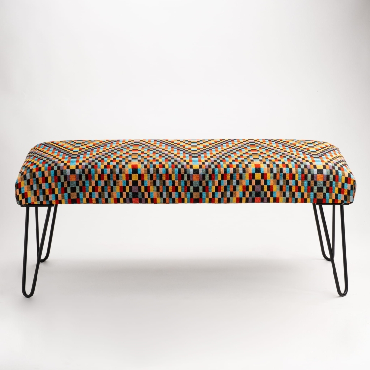 Tapicerowana ławka industrialna z kolorowym wzorem i smukłymi nogami typu pin