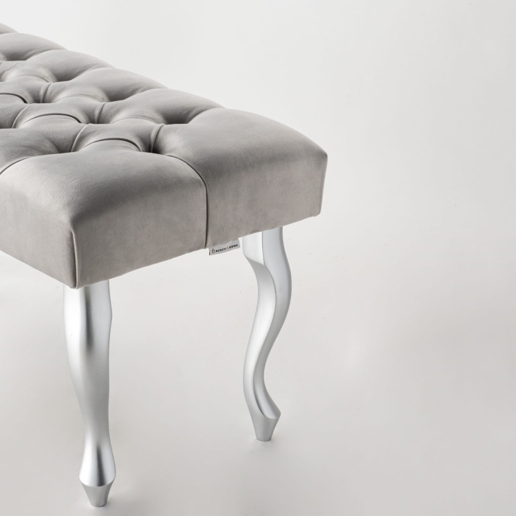 Szara ławka tapicerowana na srebrnych metalowych nogach