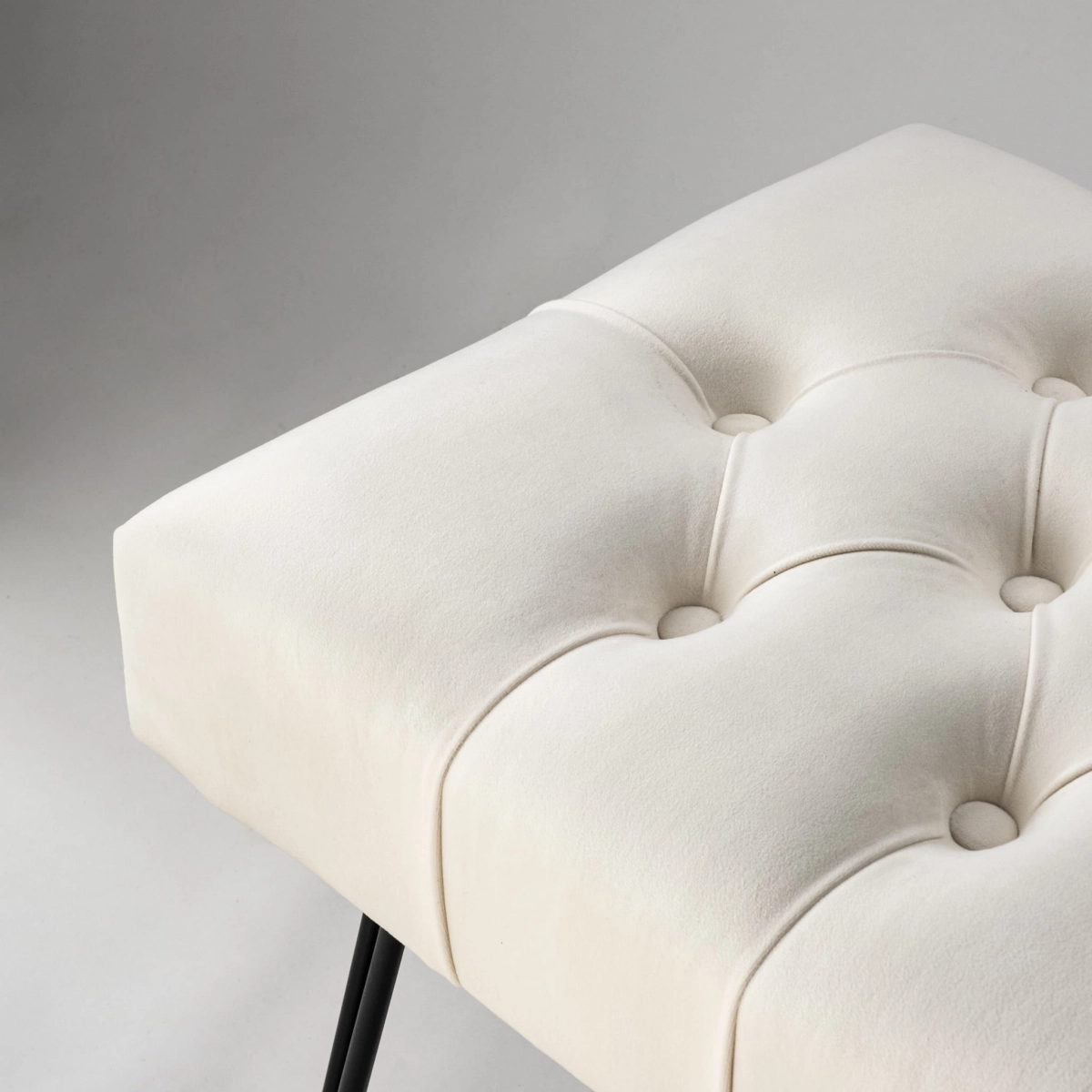 Kremowa ławka pikowana z designerskimi nogami w kształcie pinów